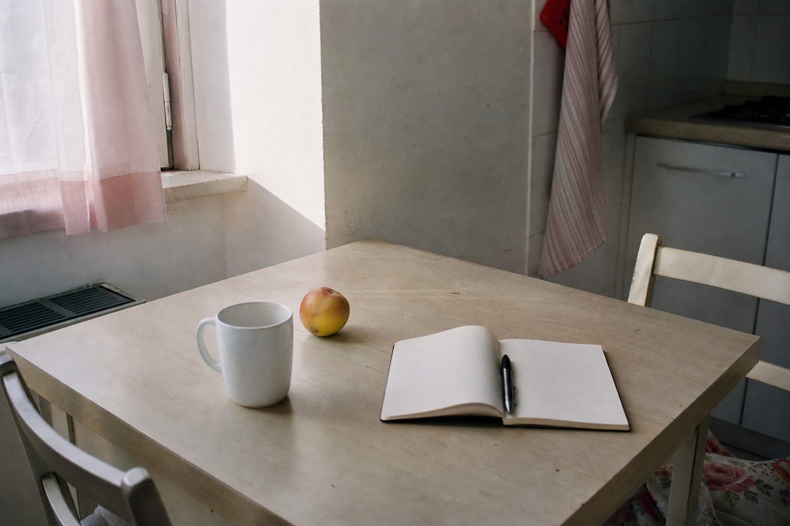 Immagine illustrativa: tazza e frutta su un tavolo di cucina al mattino.